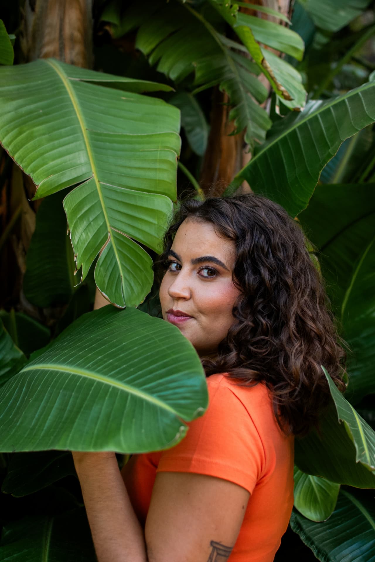 Retrato de Marisa Henriques entre folhas de strelitzia